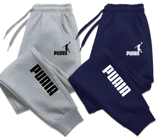 Gray and navy Puma tracksuits with logos on a white background